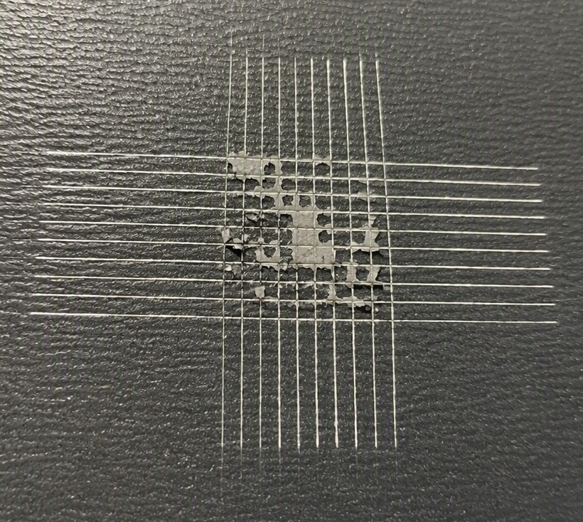 Cross-hatch test grid with coating flaked off at the cut intersections