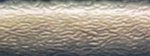 Dried ink surface under raking light showing a pebbled orange-peel texture