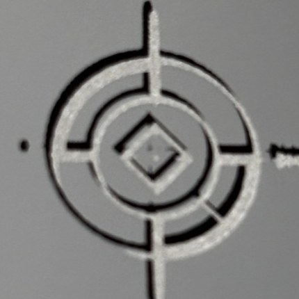 Register mark with the black layer printed offset from the silver layer