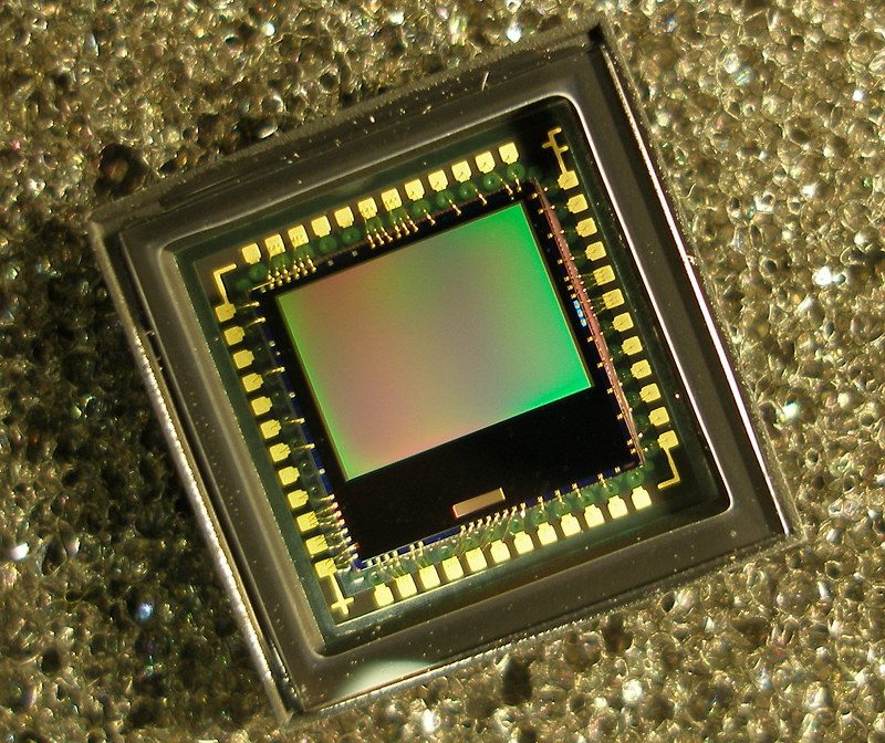 Image sensor chip in its ceramic package, gold bond wires around the die